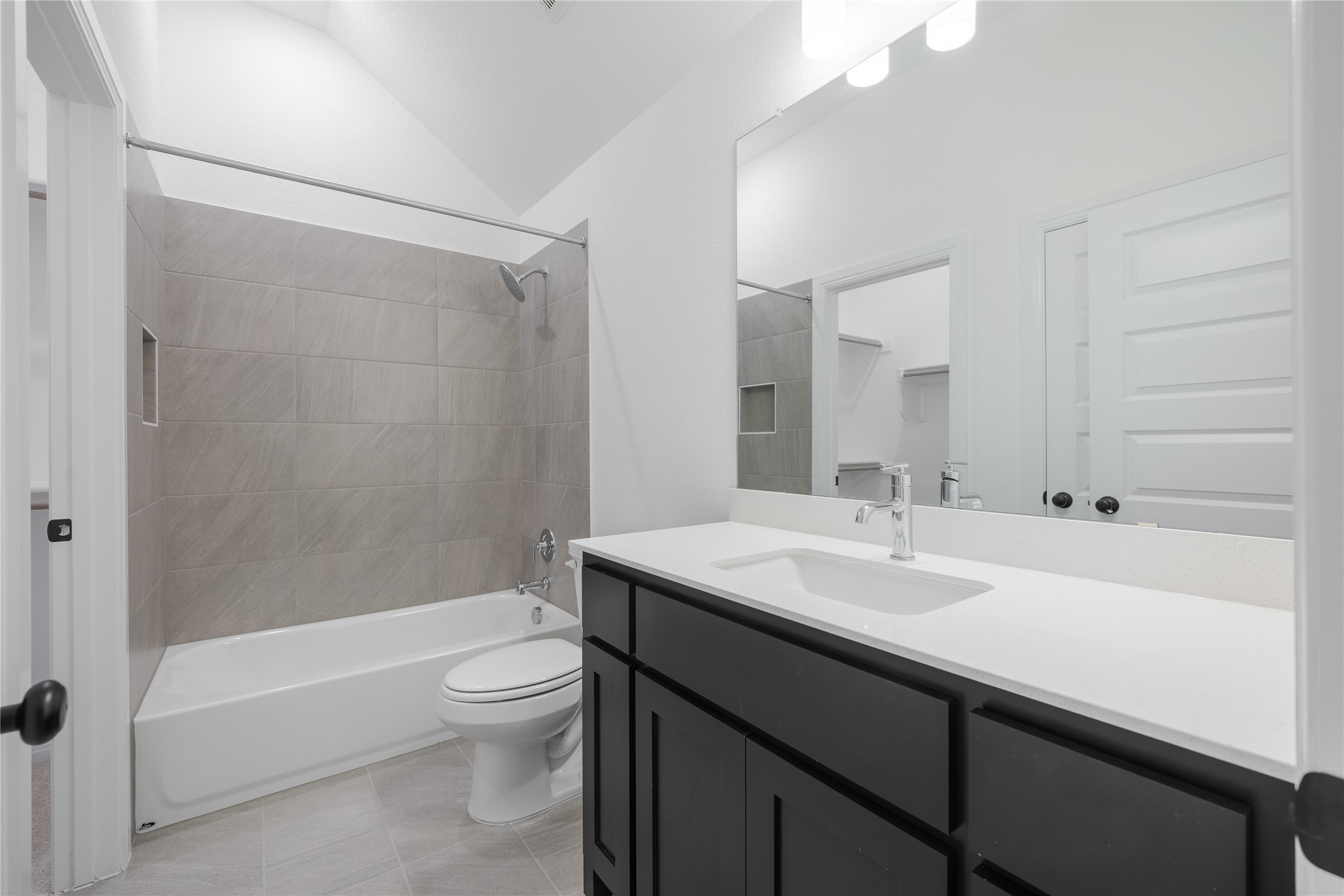 3213 Lookout Mountain Road Georgetown, TX 78628 - Photo 22 of 40 Full bathroom with vanity, bathtub / shower combination, vaulted ceiling, and light tile patterned floors