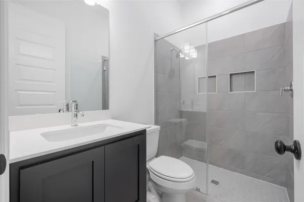 a bathroom with a sink a toilet and shower