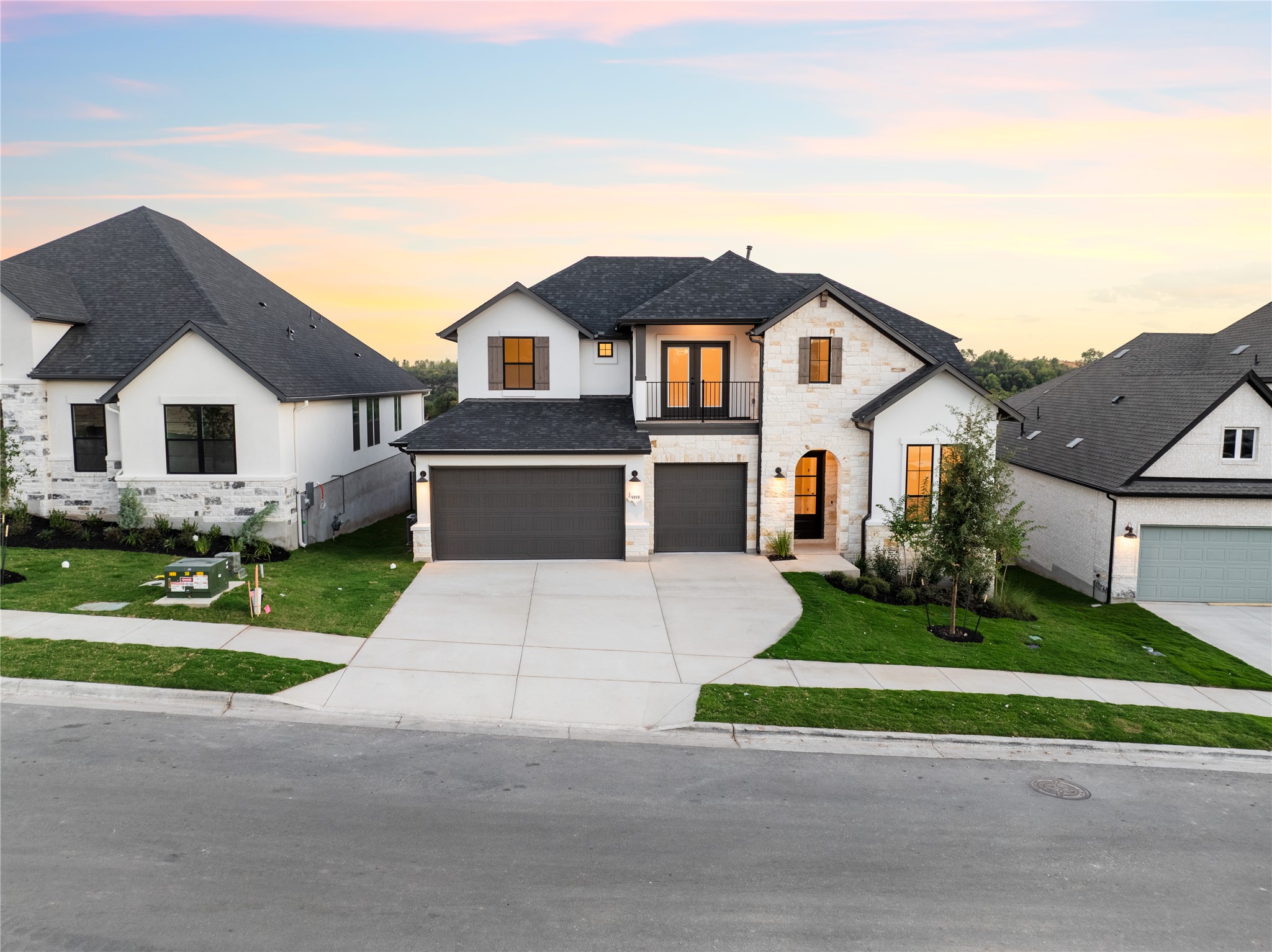 3213 Lookout Mountain Road Georgetown, TX 78628 - Photo 6 of 40 View of front facade with stone siding, a garage, driveway, a balcony, and a front lawn