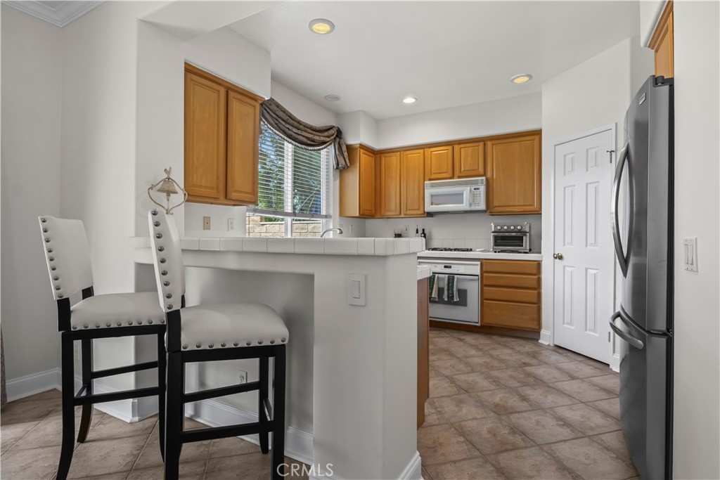 27 Rolling Ridge Rancho Santa Margarita, CA 92688 - Photo 12 of 42 a kitchen with stainless steel appliances granite countertop a stove a sink refrigerator and a refrigerator