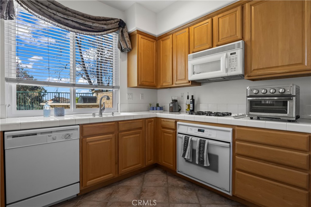 27 Rolling Ridge Rancho Santa Margarita, CA 92688 - Photo 13 of 42 a kitchen with stainless steel appliances granite countertop a sink and cabinets