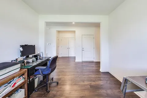 a view of a workspace with furniture and wooden floor