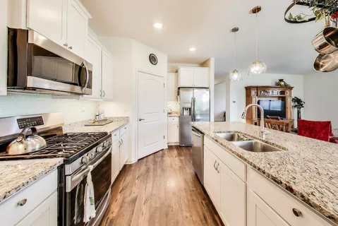 a kitchen with stainless steel appliances granite countertop a sink stove and refrigerator