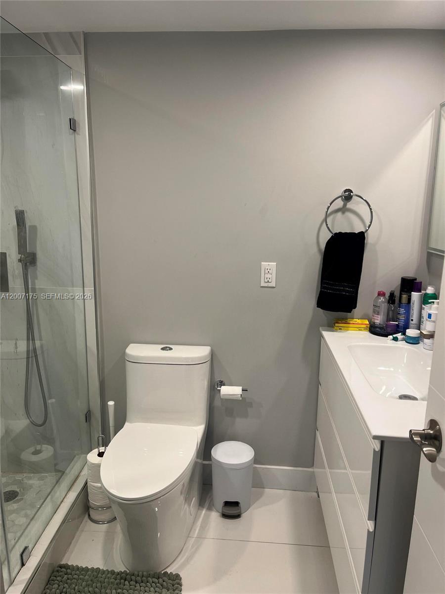 540 Brickell Key Drive, Unit 1809 Miami, FL 33131 - Photo 20 of 25 a white toilet sitting next to a bathroom sink and a shower