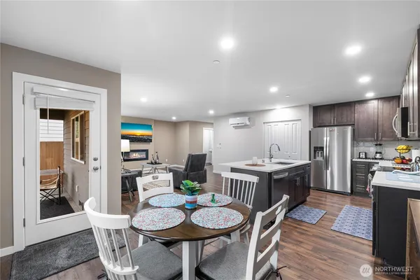 a kitchen with a dining table chairs and refrigerator