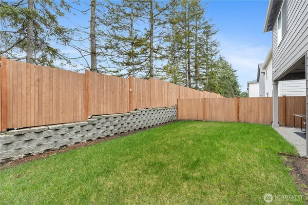 a view of a yard with wooden fence