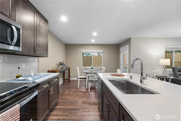 a kitchen with stainless steel appliances granite countertop a sink stove and refrigerator