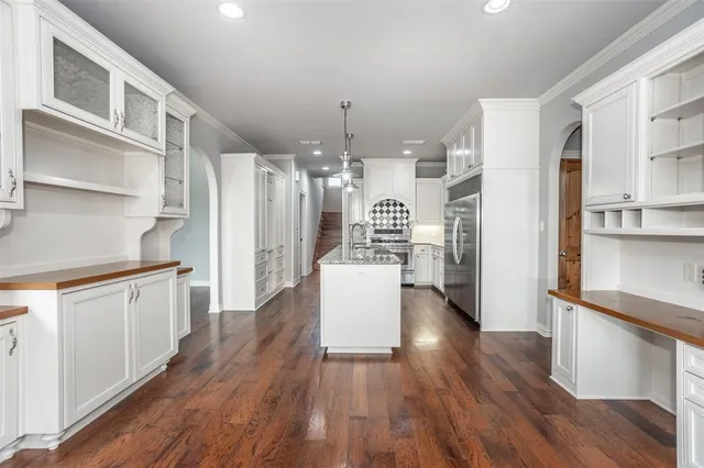 a kitchen with stainless steel appliances a refrigerator and wooden floor