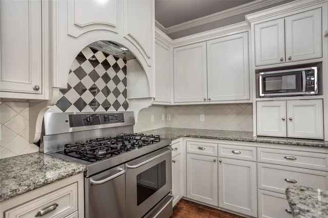 a kitchen with granite countertop cabinets and steel stainless steel appliances