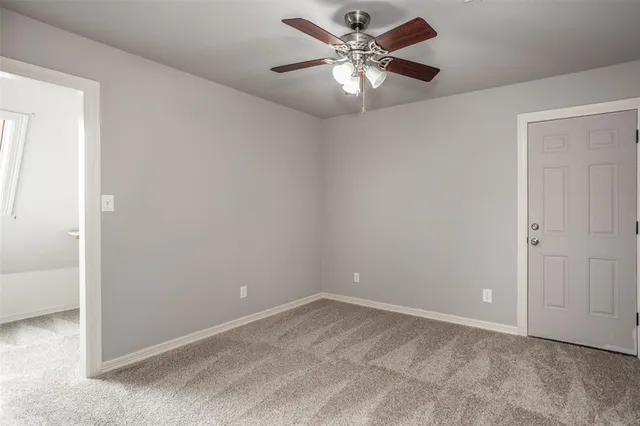 an empty room with a chandelier fan