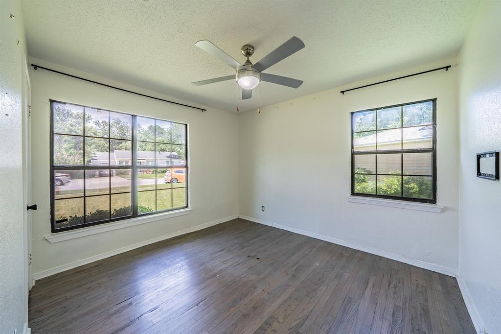 11528 Sinclair Avenue Dallas, TX 75218 - Photo 10 of 16 Room featuring wood-finish flooring, white walls, and a ceiling fan with integrated lighting
