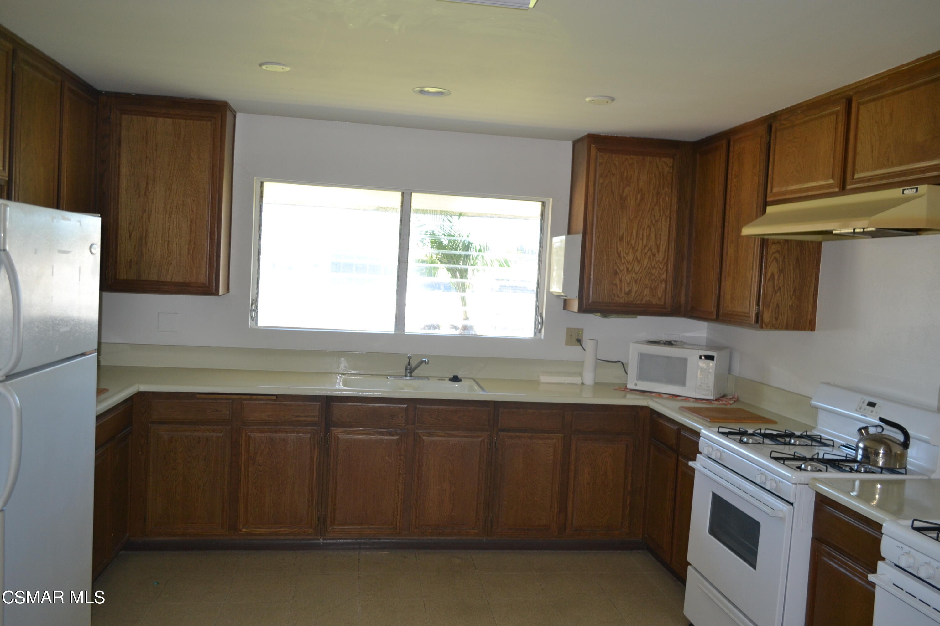 6480 Katherine Road, Unit 70 Simi Valley, CA 93063 - Photo 19 of 28 a kitchen with a sink stove and cabinets
