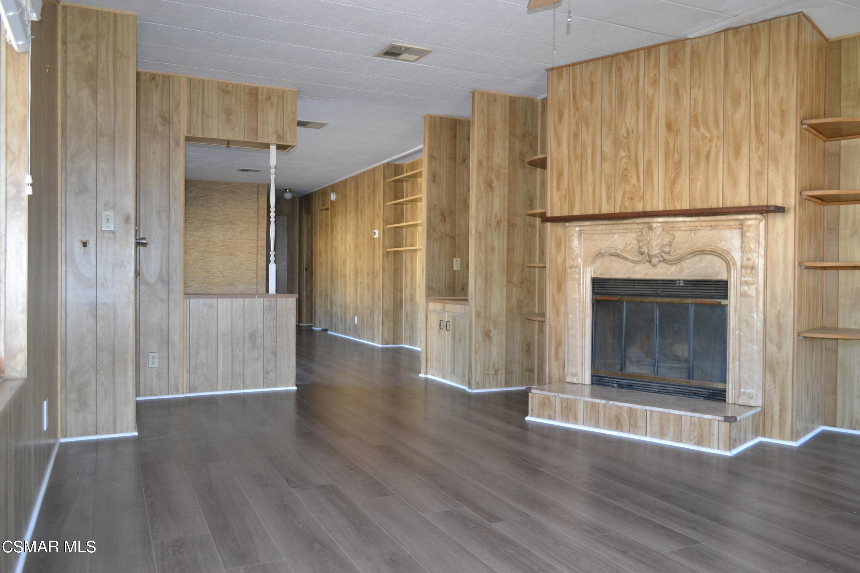 6480 Katherine Road, Unit 70 Simi Valley, CA 93063 - Photo 2 of 28 a view of an empty room with wooden floor and a fireplace