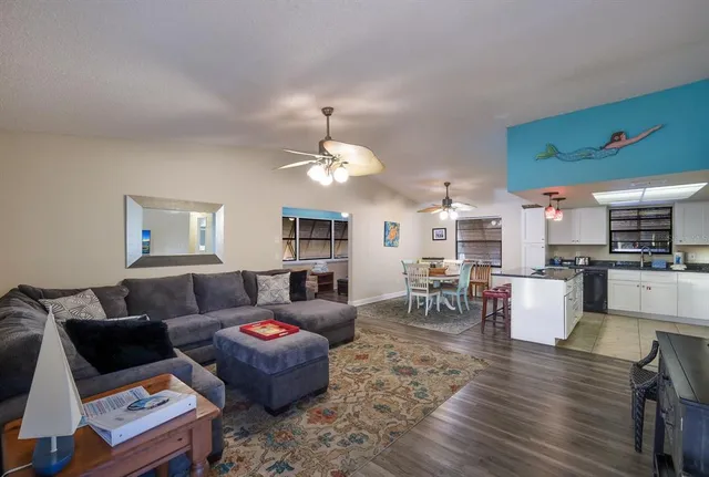 a living room with lots of furniture and view of kitchen