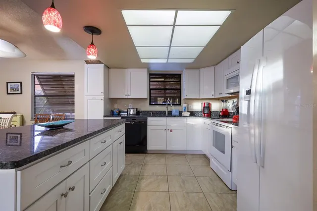 a kitchen with stainless steel appliances granite countertop a sink a stove and cabinets