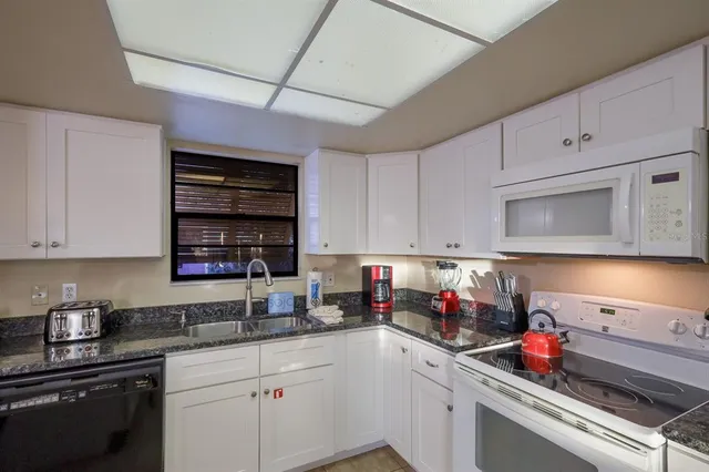 a kitchen with stainless steel appliances granite countertop a sink dishwasher stove and cabinets