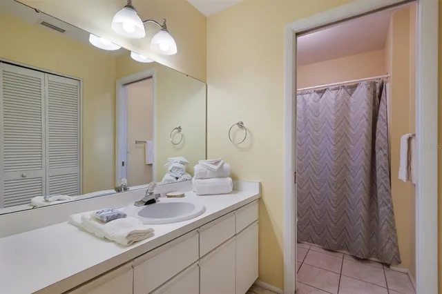 a bedroom with a bed and a flat tv screen on dresser