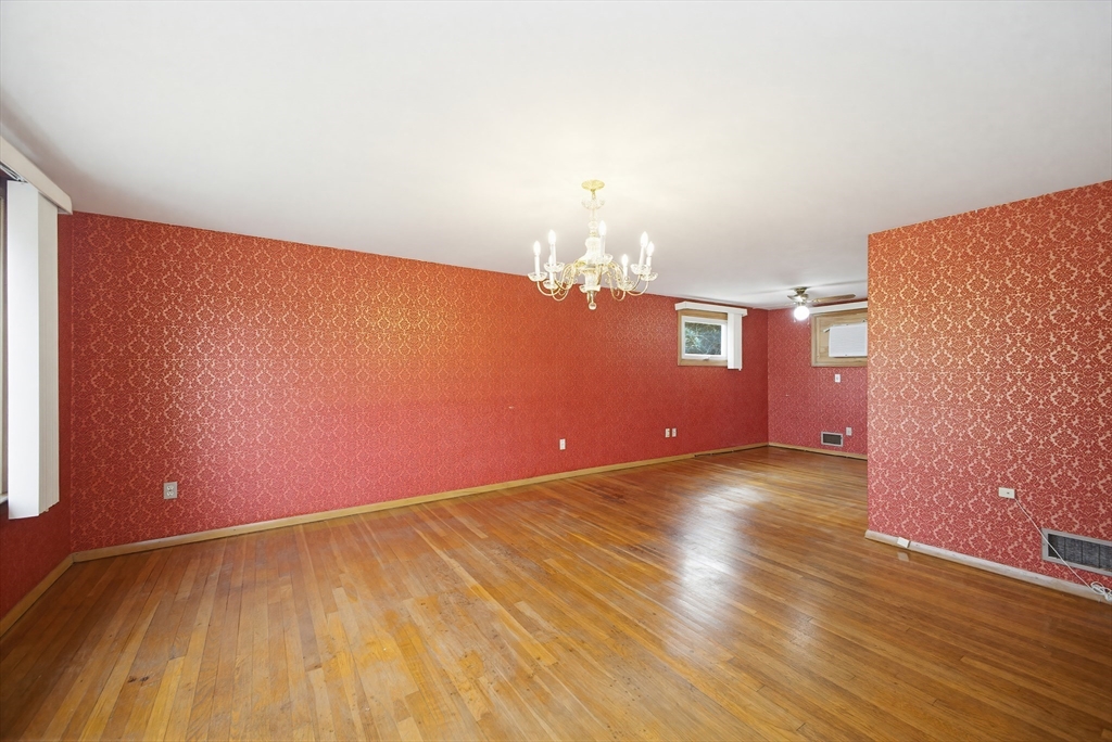 111 Almy Road Somerset, MA 02726 - Photo 7 of 42 an empty room with wooden floor and chandelier fan
