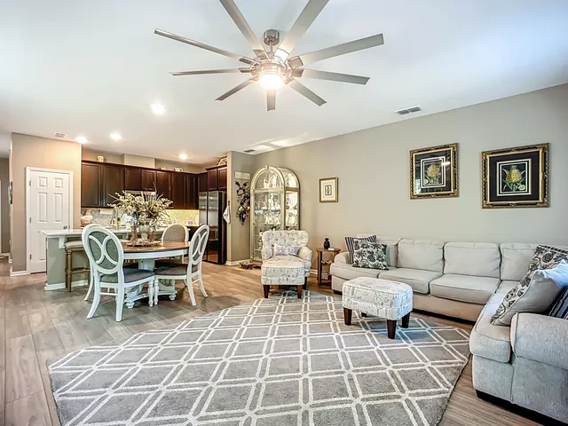 a living room with furniture a clock and a large window