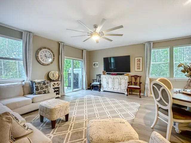 a living room with furniture a dining table and a clock