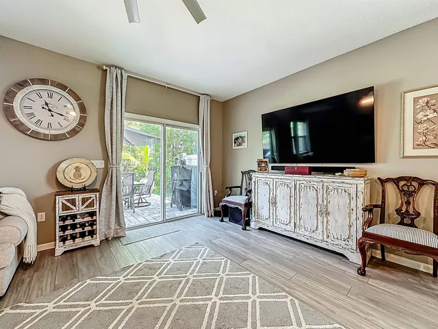 a living room with furniture a flat screen tv and a large window