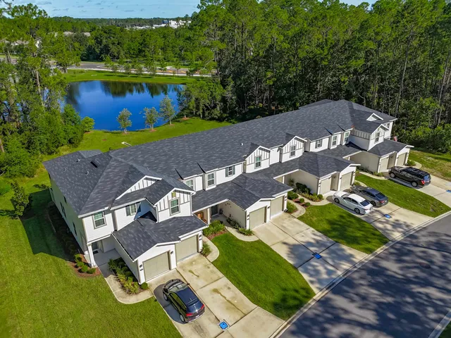 an aerial view of multiple houses with yard