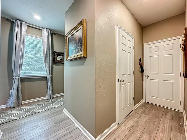 a view of a hallway with wooden floor and closet