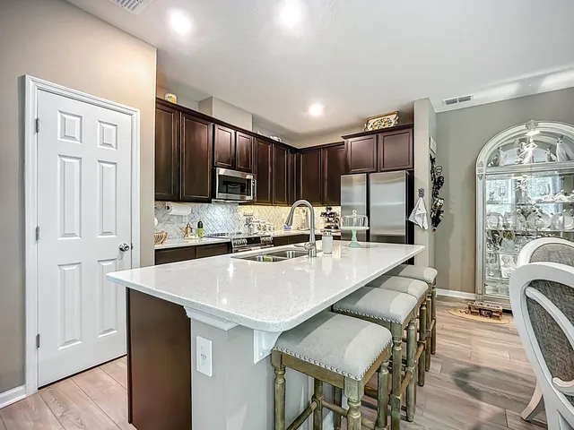 a kitchen with a table chairs refrigerator and cabinets