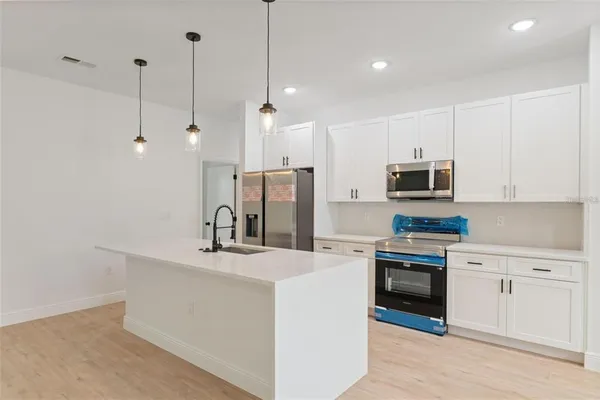 a kitchen with stainless steel appliances a refrigerator sink and microwave
