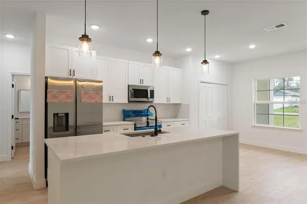 a large white kitchen with stainless steel appliances
