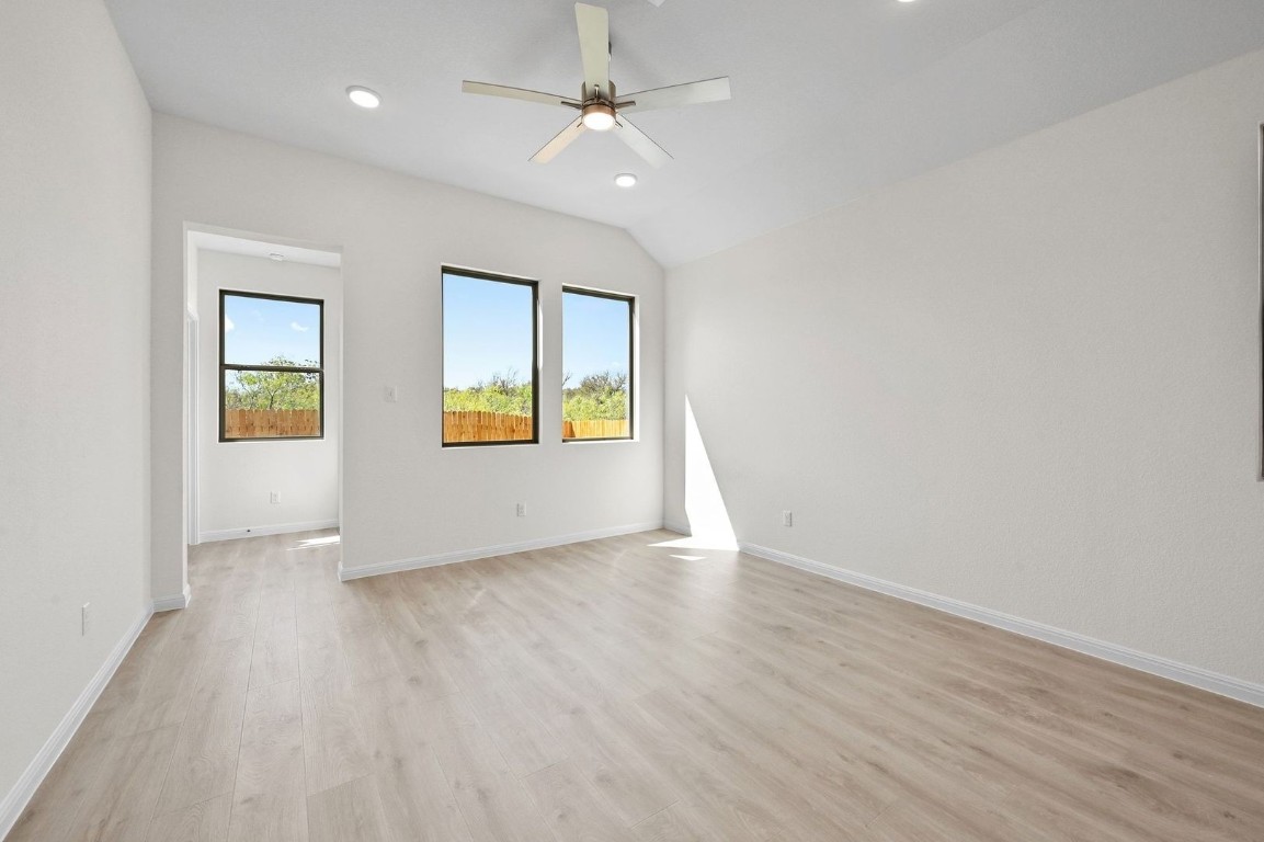 270 Bendecido Loop Elgin, TX 78621 - Photo 11 of 39 an empty room with wooden floor ceiling fan and windows