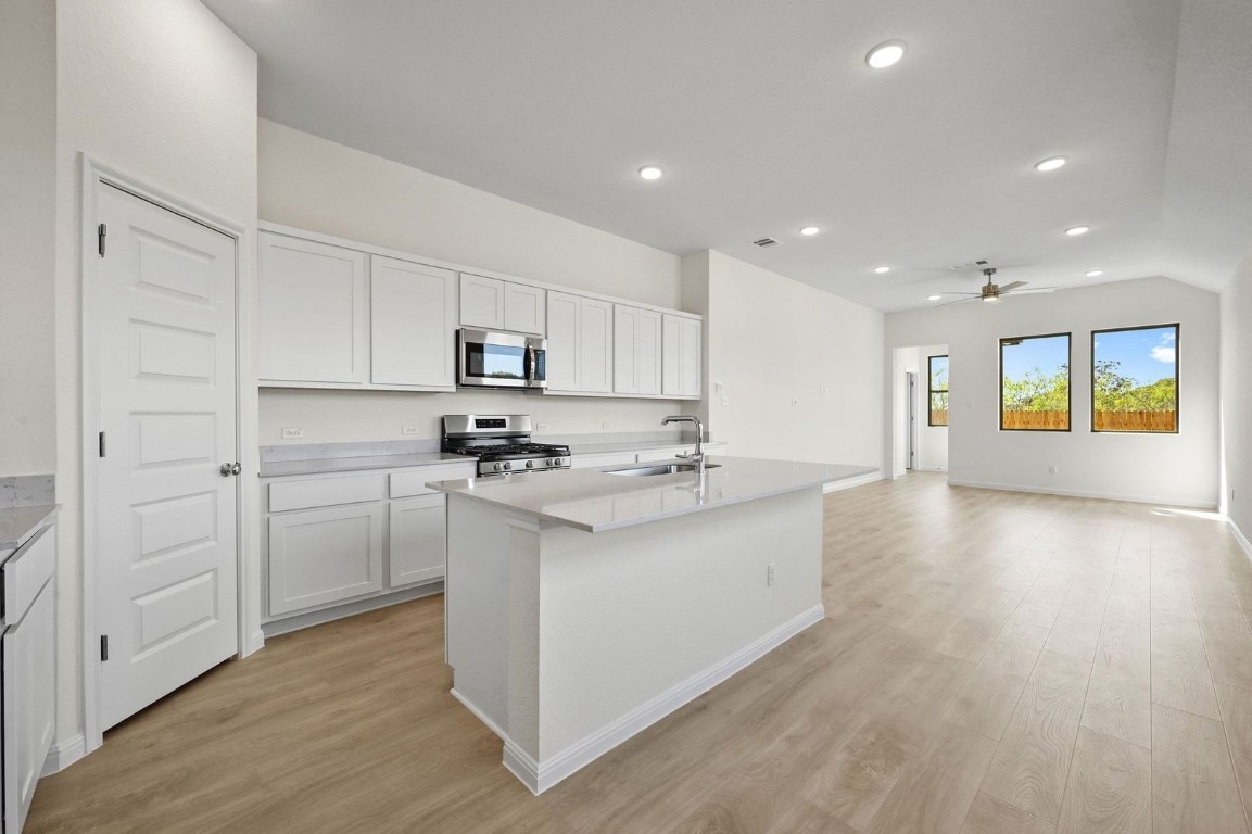 270 Bendecido Loop Elgin, TX 78621 - Photo 6 of 39 a kitchen with stainless steel appliances granite countertop a stove a sink and a refrigerator