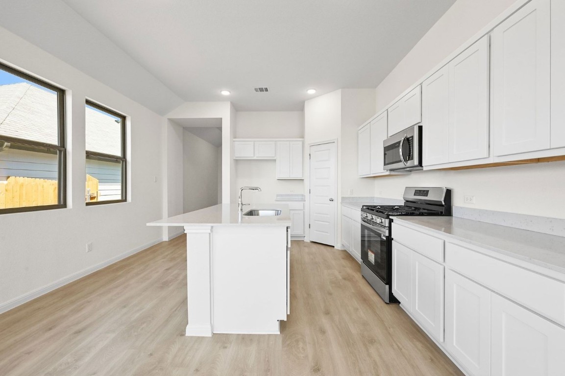 270 Bendecido Loop Elgin, TX 78621 - Photo 8 of 39 a kitchen with cabinets wooden floor and a sink