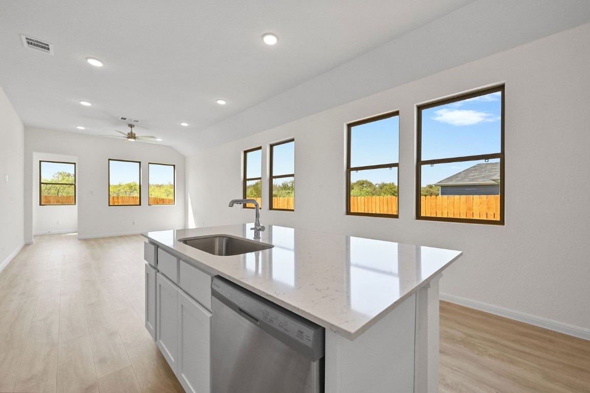 270 Bendecido Loop Elgin, TX 78621 - Photo 9 of 39 a kitchen with stainless steel appliances granite countertop a sink and a wooden floors