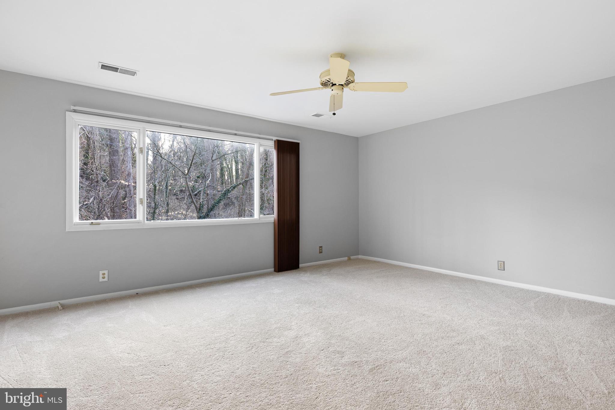 10 Brandywine Falls Road, Unit C010 Wilmington, DE 19806 - Photo 16 of 29 an empty room with windows and chandelier fan