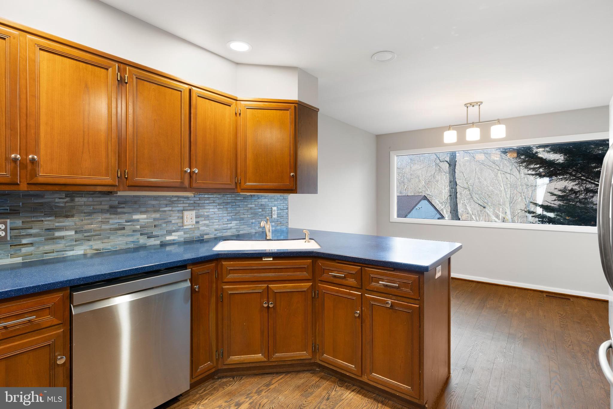 10 Brandywine Falls Road, Unit C010 Wilmington, DE 19806 - Photo 8 of 29 a kitchen with stainless steel appliances granite countertop wooden cabinets a sink and dishwasher
