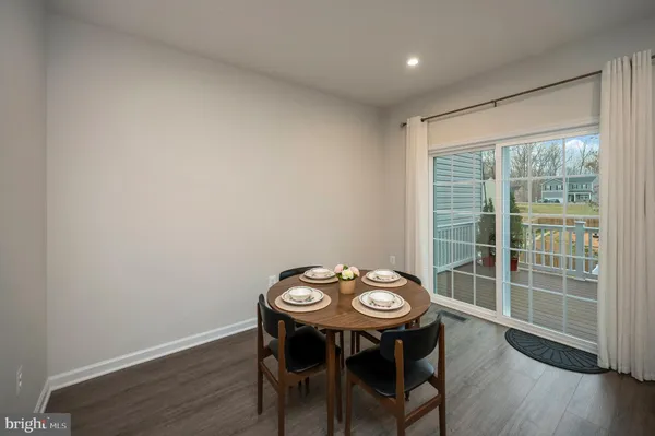 a kitchen with stainless steel appliances kitchen island a table and chairs in it