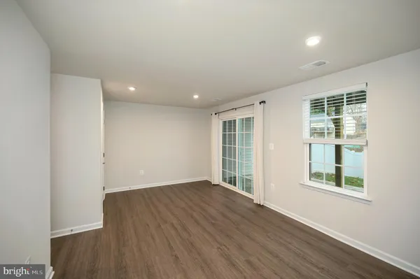 a kitchen with stainless steel appliances kitchen island granite countertop a stove top oven a sink dishwasher a dining table and chairs with wooden floor