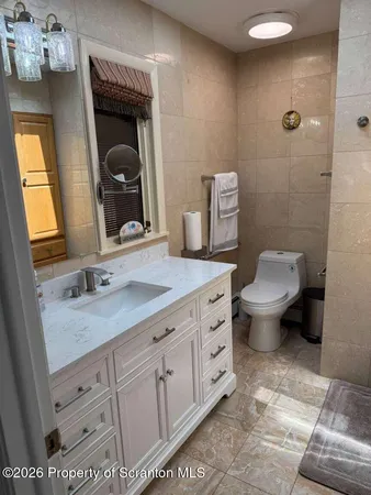 a bathroom with a granite countertop toilet sink and mirror