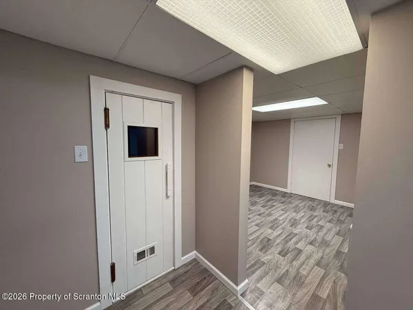 a view of a hallway with wooden floor and cabinet