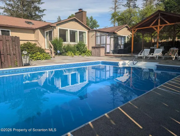 a view of a house with pool and sitting area