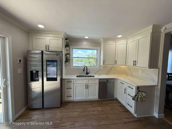 a large kitchen with a sink and refrigerator