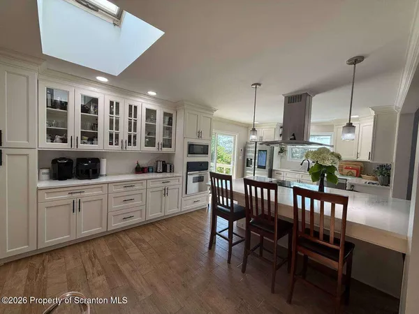 a kitchen with a dining table chairs and white cabinets