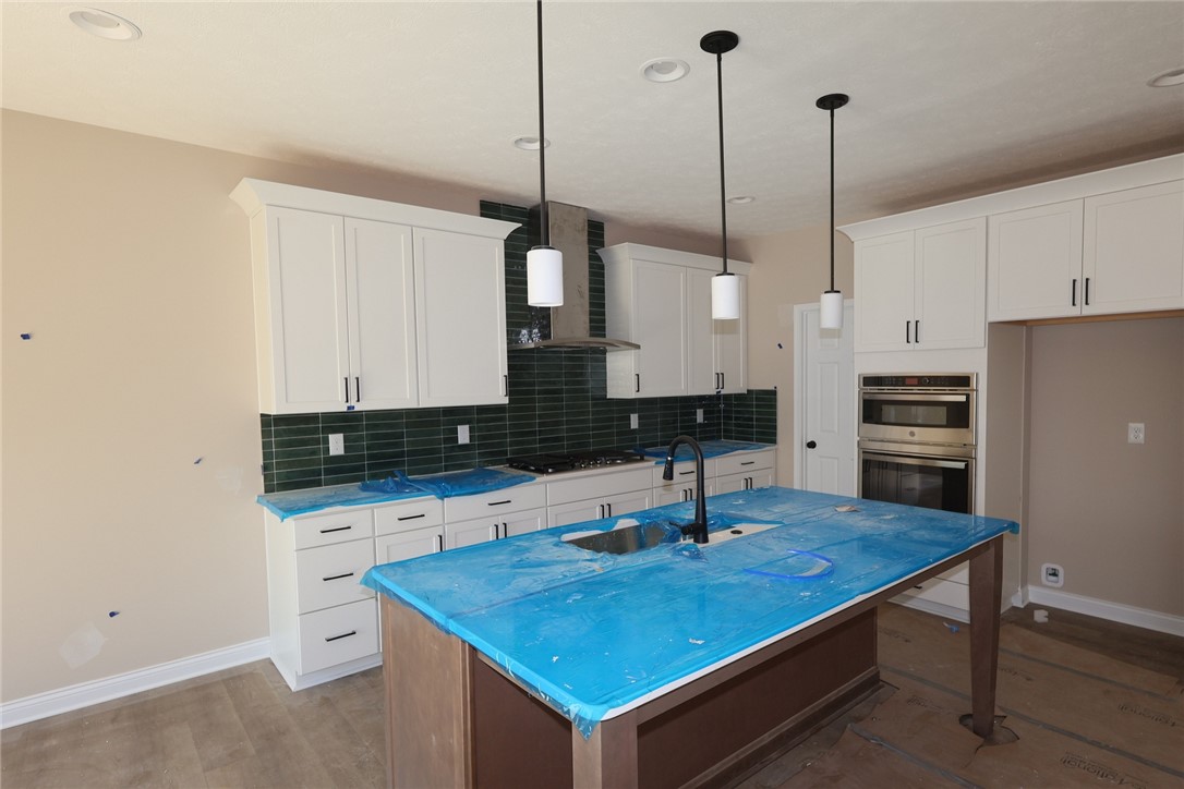 240 Tilly Court, Unit 5 Springboro, OH 45066 - Photo 22 of 26 This newly constructed kitchen features an island, pendant lights, and modern appliances.