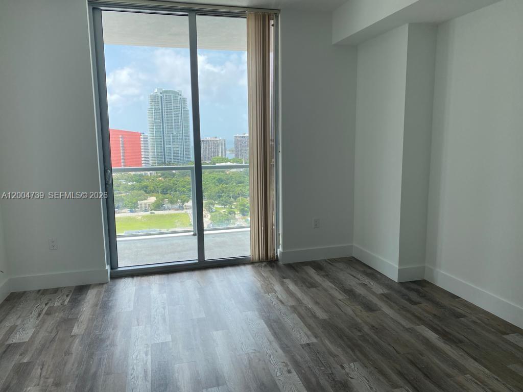 79 Southwest 12th Street, Unit 2403S Miami, FL 33130 - Photo 12 of 12 a view of an empty room and wooden floor and windows