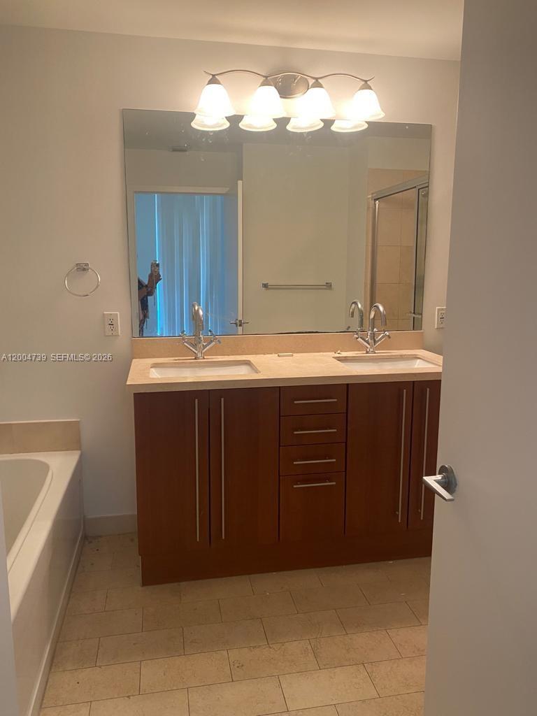 79 Southwest 12th Street, Unit 2403S Miami, FL 33130 - Photo 3 of 12 a bathroom with a sink and a mirror
