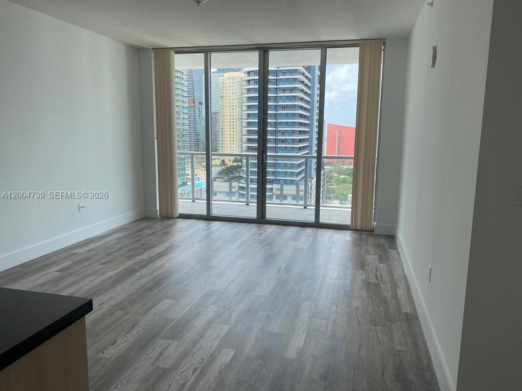 79 Southwest 12th Street, Unit 2403S Miami, FL 33130 - Photo 5 of 12 wooden floor in an empty room with a window