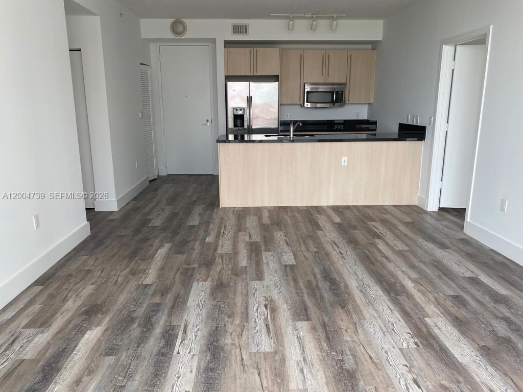 79 Southwest 12th Street, Unit 2403S Miami, FL 33130 - Photo 9 of 12 a kitchen with wooden floors and white appliances