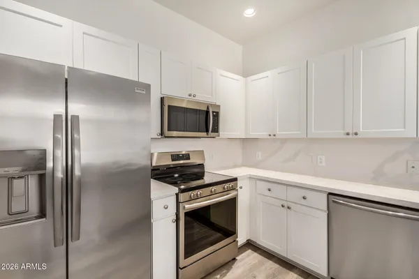 a kitchen with white cabinets and stainless steel appliances