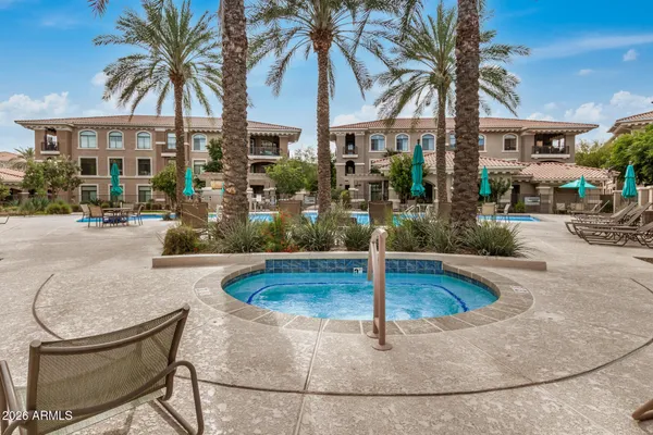 a view of a backyard with swimming pool and sitting area